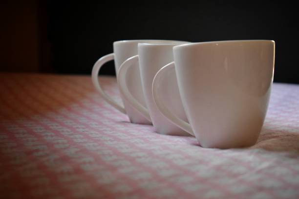 istock three Coffee cups on old pink color kitchen table. Top view with copy space for your text, india 1309936157