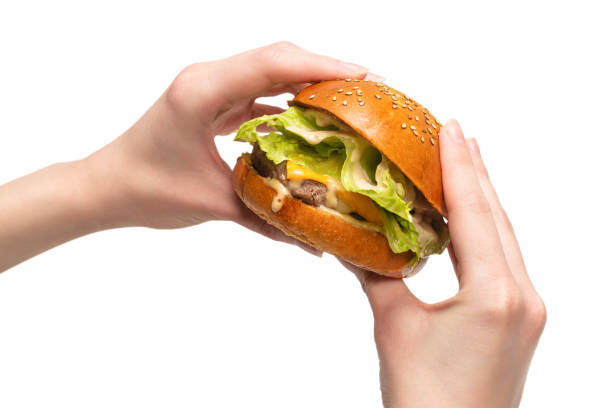 istock Hamburger in woman hands isolated on a white background. 1309936372
