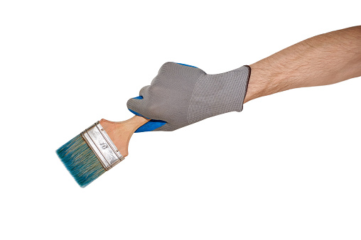 A man's gloved hand holds a brush. on a white background