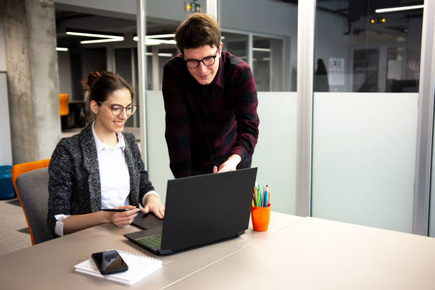 istock Two colleagues discussing together about a project in modern office 1309938954