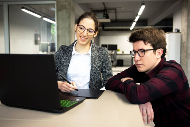 istock Two colleagues discussing together about a project in modern office 1309938958