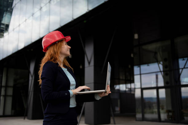 istock Female construction manager using laptop and smilling 1309939297