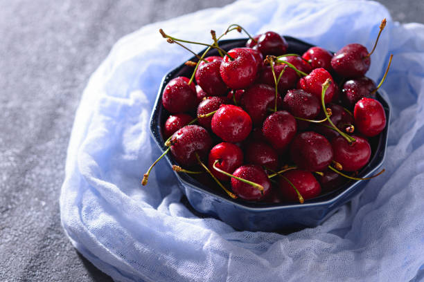 istock summer cherries with drop in blue bowl on blue gauze 1309939500