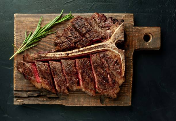 istock Grilled T-bone steak on a stone table. With rosemary and spices. 1309940362