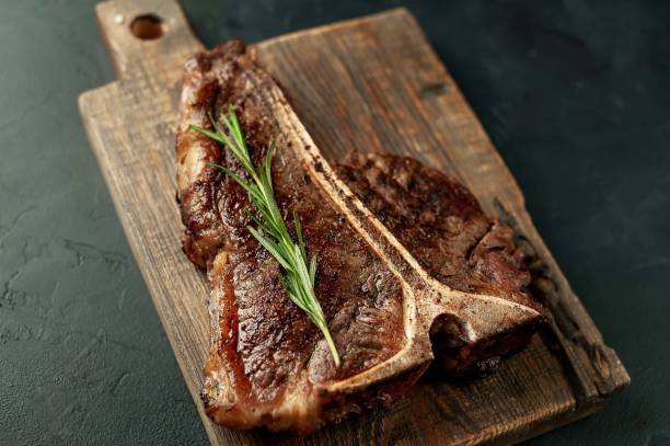 istock Grilled T-bone steak on a stone table. With rosemary and spices. 1309940468