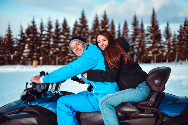 istock Cute Couple Riding Snowmobile On Mountain In Winter 1309941709