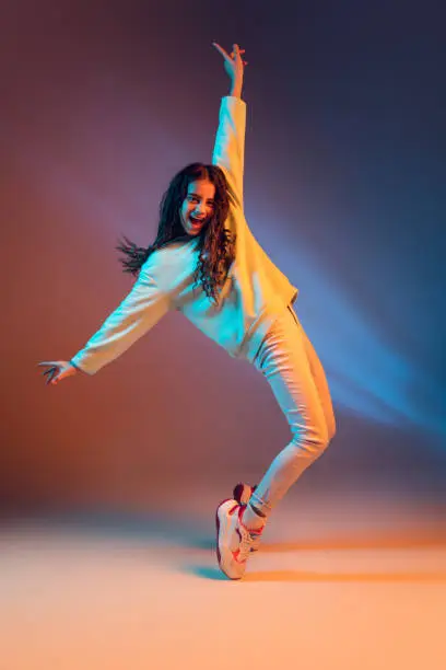 Photo of Portrait of young beautiful girl isolated on gradient background in neon light