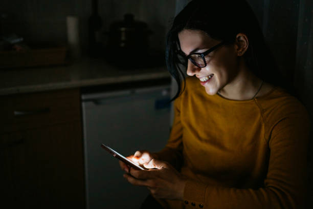 istock Woman using phone in kitchen at night 1309945058