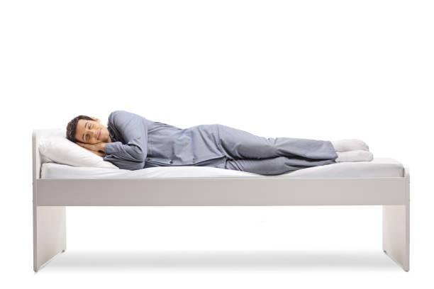 tiro de comprimento total de um homem dormindo peacly em uma cama de solteiro - mattress bed cushion isolated - fotografias e filmes do acervo