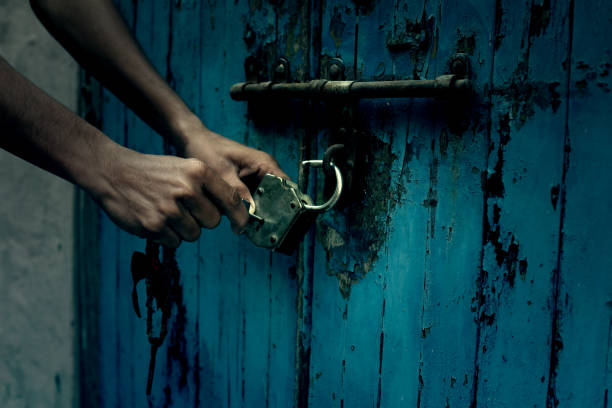 unlocking abandoned house - lock door horror gate imagens e fotografias de stock