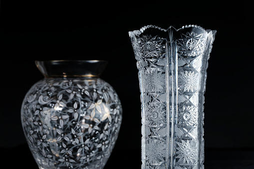 A classic crystal vase with a modern one on black background