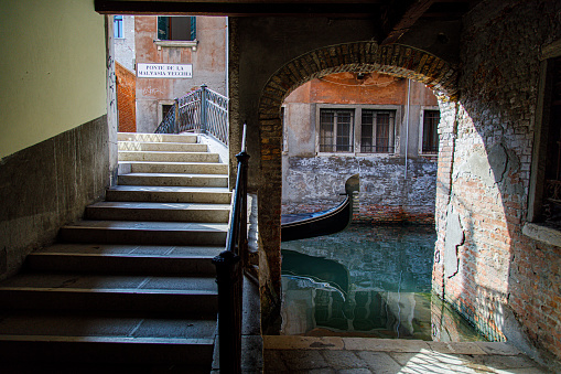 Gondola under bridge, day, Venice, Italy