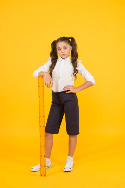 istock Where student comes first. Serious small student holding wooden ruler on yellow background. Little student learning maths and geometry at lyceum. Primary school student on September 1 1309947738