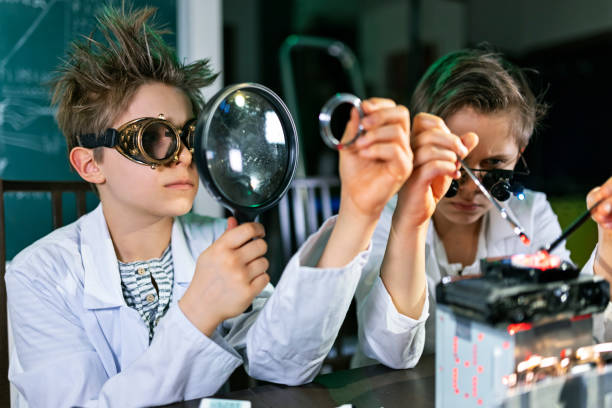 Little scientists wearing lab coats and steampunk goggles are working on their new invention - a mysterious power source that will solve humanity energy problems.They are assembling the device.Shot with Canon R5