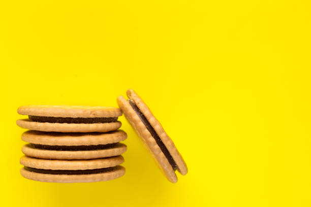 istock Sandwich biscuits with a chocolate filling on a yellow background. 1309949054