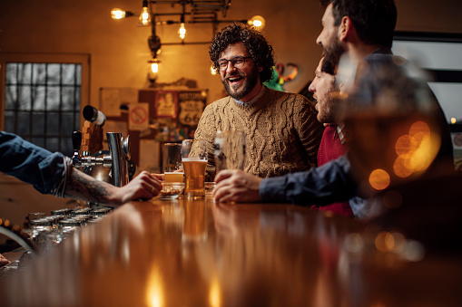 Grupo de hombres felices bebiendo cerveza en el bar photo