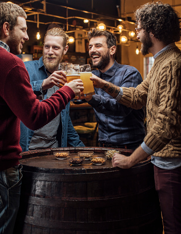 Group of friends having fun at the pub drinking beer, celebration concept
