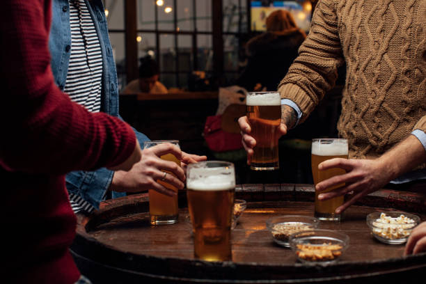 istock Beer and Snacks: Group of Unrecognizable Men at the Bar Together, a Close Up 1309949314