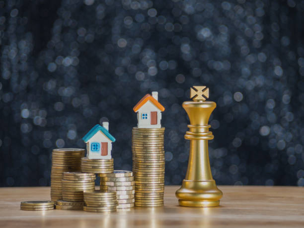istock Gold coins and home on coins stack with chess gold king on coins stack. Concept for loan, property ladder, financial, mortgage, real estate investment, taxes, housing loan and bonus. 1309949531