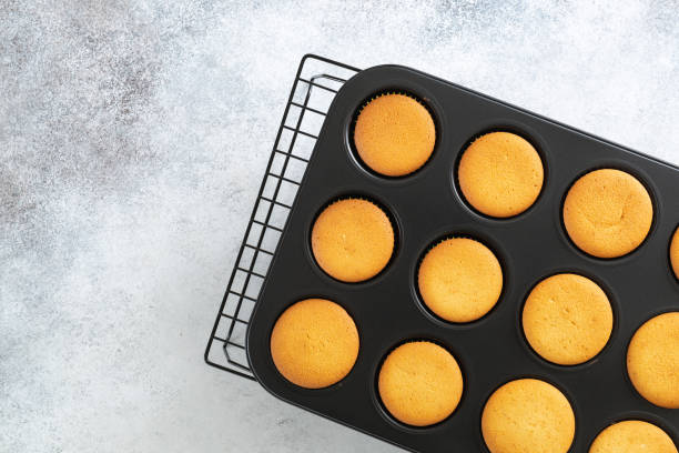 istock Freshly baked vanilla cupcakes cool in baking dish 1309949794