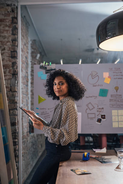 new normal concept: side view of a young african american young female entrepreneur holding files, alone at the office - drawing women expertise business imagens e fotografias de stock