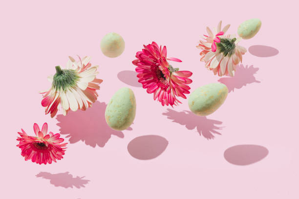 istock Creative, modern composition made of pink flowers and white eggs floating above pastel background. Minimal, bold Spring or Easter concept. 1309952287