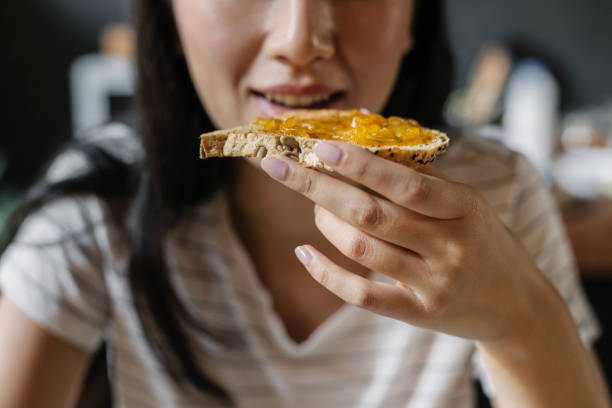 오늘의 가장 중요한 식사 : 집에서 아침 식사를 먹는 인식 할 수없는 젊은 여성 - carbohydrate 뉴스 사진 이미지