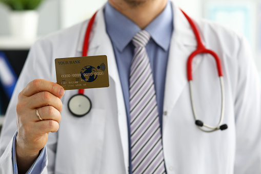 Male GP holding banking card in arm closeup