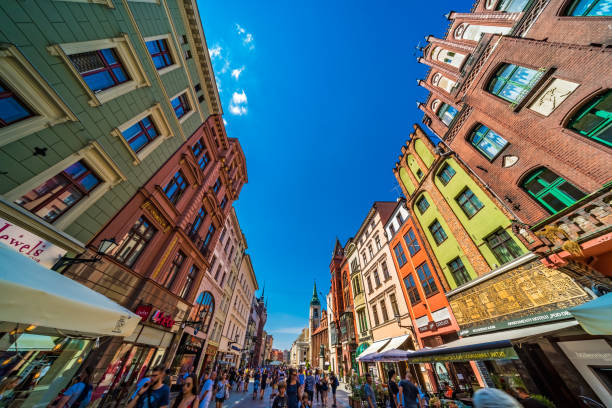 Torun, Poland - August 2020 : Crowds of people walking through the bustling centre of colourful renovated historic tenement houses and buildings in the historic Old Town