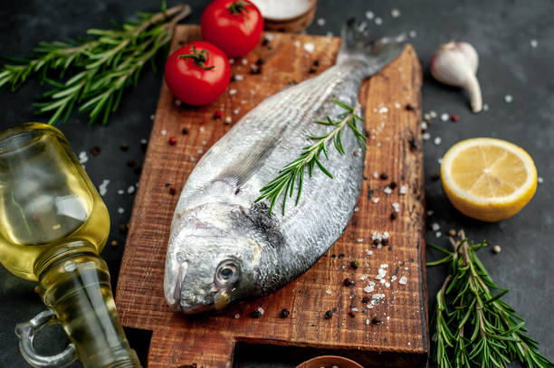 istock Raw dorado fish with ingredients on stone background 1309956777