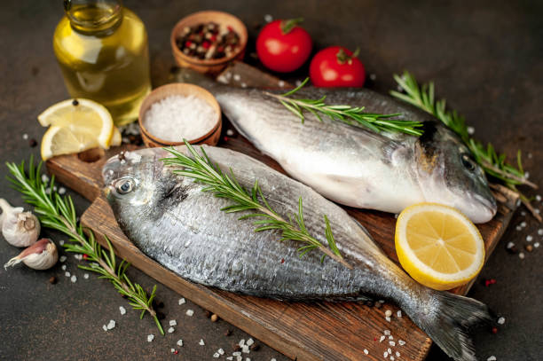 istock Raw dorado fish with ingredients on stone background 1309957469