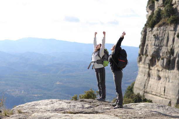 istock Excited hikkers celebrating raising arms in the mountain 1309957738