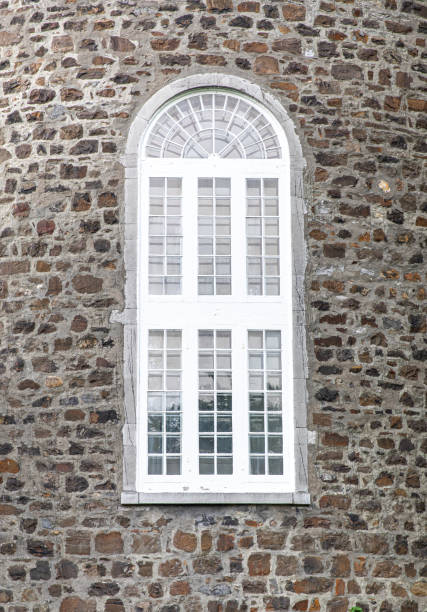 glass with an arched white frame on a stoned surface