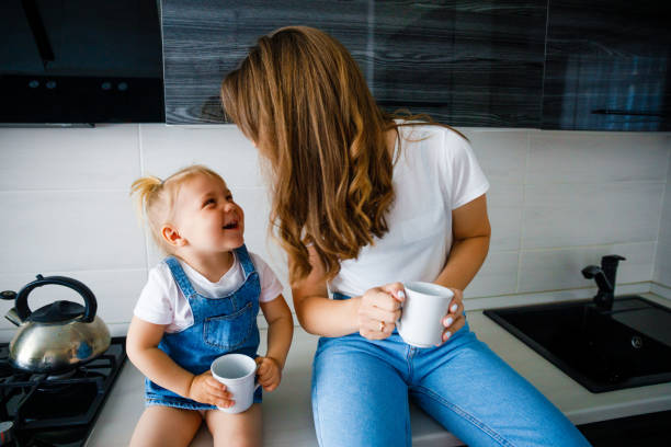istock Mother is drinking tea in the kitchen with her little daughter. 1309960348