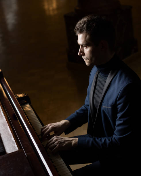 istock Pianists man playing piano in the dark room 1309960371