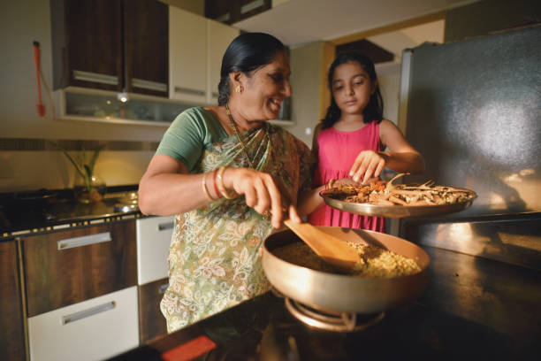 istock Girl helping her grandmother in making spices 1309960421