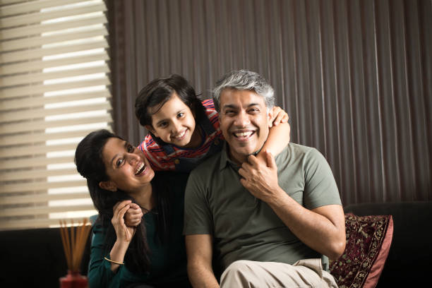 Cute girl playing with father and mother at home