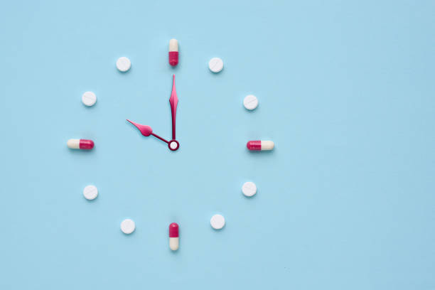 istock Clock created from pills and capsules on pastel blue background. Right time for using medicines. Flat lay. 1309960944