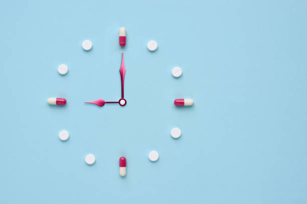 istock Clock created from pills and capsules on pastel blue background. Right time for using medicines. Flat lay. 1309960946
