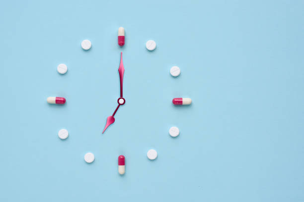 istock Clock created from pills and capsules on pastel blue background. Right time for using medicines. Flat lay. 1309960951