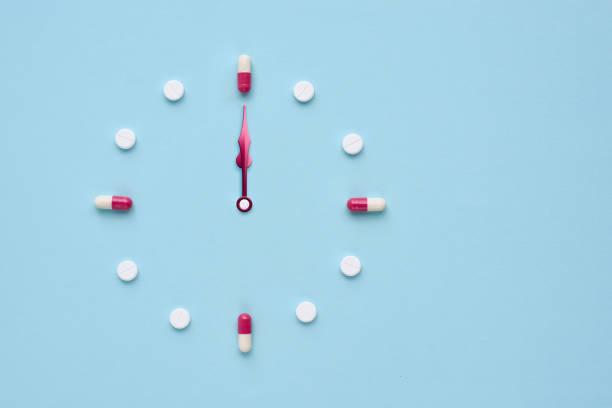 istock Clock created from pills and capsules on pastel blue background. Right time for using medicines. Flat lay. 1309960954