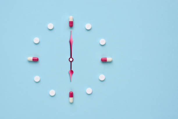istock Clock created from pills and capsules on pastel blue background. Right time for using medicines. Flat lay. 1309960955