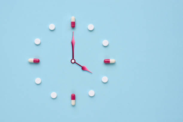 istock Clock created from pills and capsules on pastel blue background. Right time for using medicines. Flat lay. 1309960958