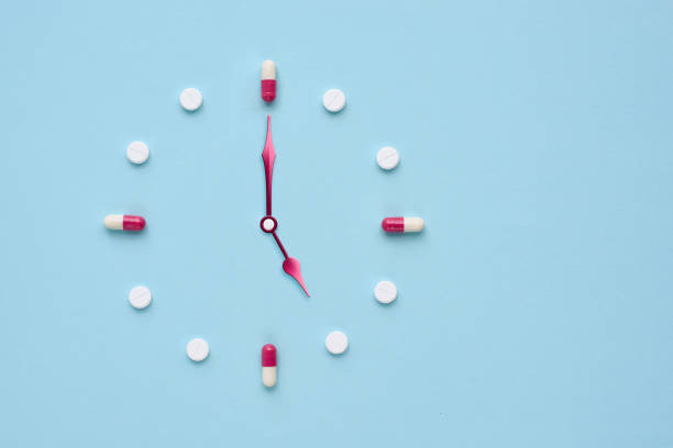 istock Clock created from pills and capsules on pastel blue background. Right time for using medicines. Flat lay. 1309960964