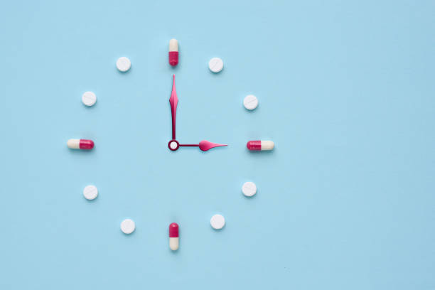 istock Clock created from pills and capsules on pastel blue background. Right time for using medicines. Flat lay. 1309960965