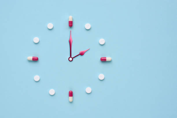 istock Clock created from pills and capsules on pastel blue background. Right time for using medicines. Flat lay. 1309960968