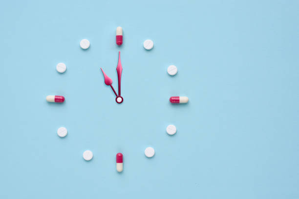 istock Clock created from pills and capsules on pastel blue background. Right time for using medicines. Flat lay. 1309960974
