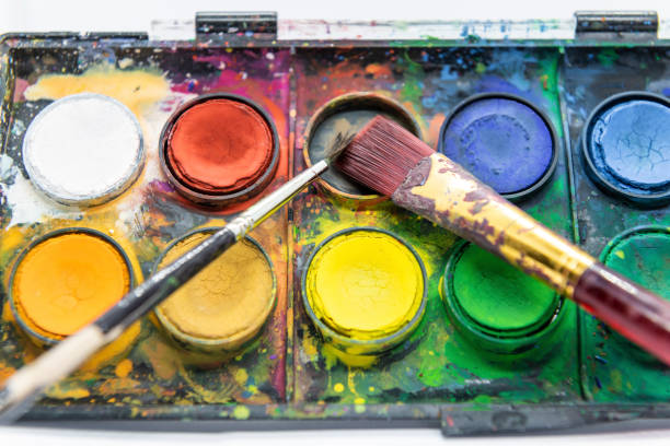 Close-up colored watercolor paints and brush