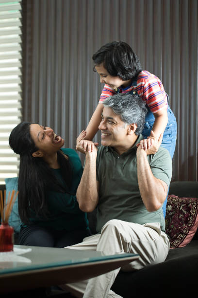 istock Daughter having fun with parents at home 1309962437