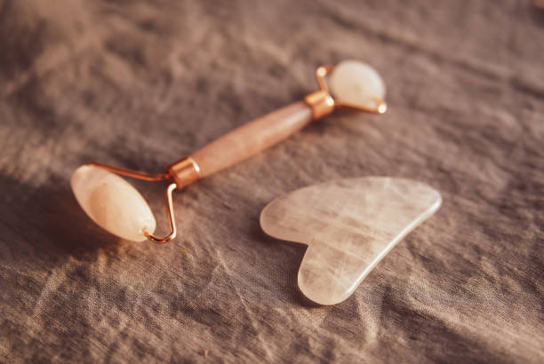 rosa gua sha stein und rolle für massage und blume - gua sha stock-fotos und bilder